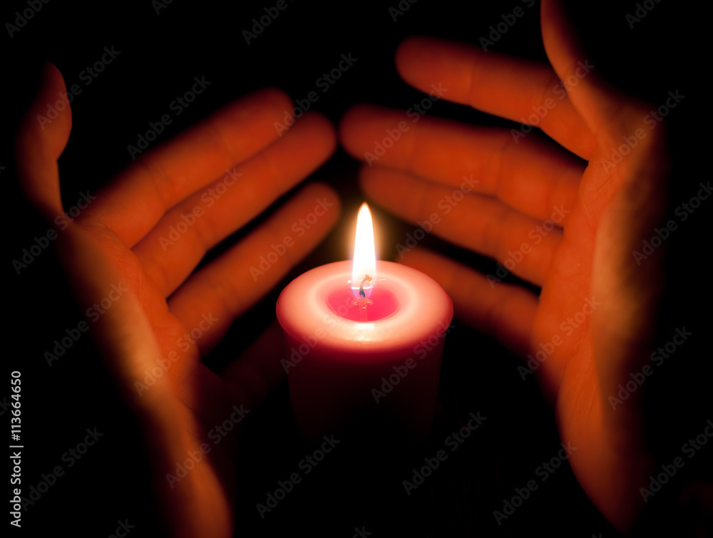 hand holding a burning candle in dark hand holding a burning candle in dark