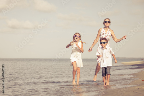 Mother and children playing on the beach at the day time.