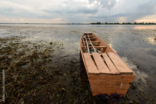 An old boat on fresh water algae in reserviour,Thailand photo