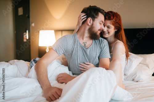 Sensual couple in bed being romantic