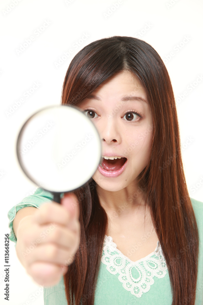 Japanese woman wearing a green summer dress with a magnifying glass Japanese woman wearing a green summer dress with a magnifying glass