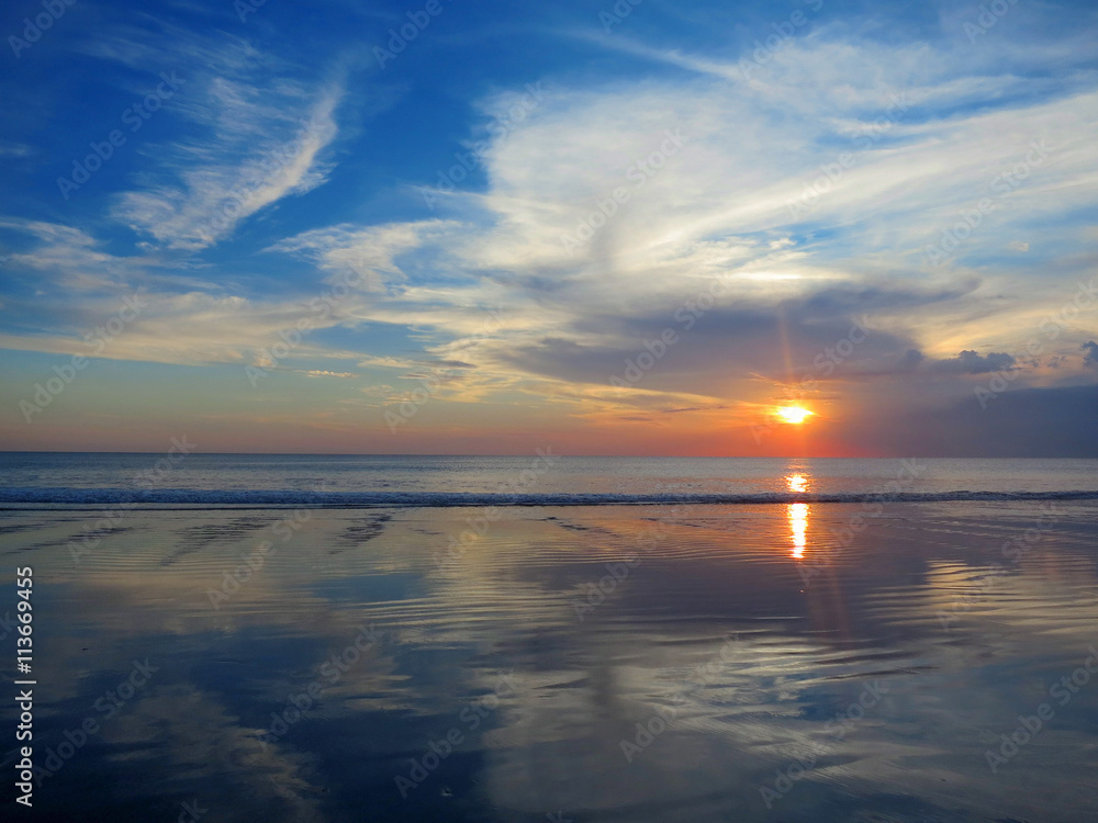 Beautiful sunset sky with reflection at Kuta beach, Bali