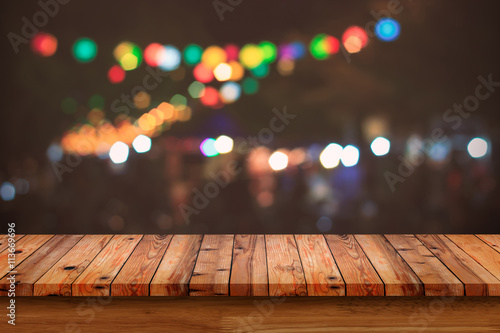 Empty wooden table with bokeh abstract light background.