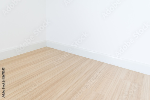 White wall with a hardwood wooden floor