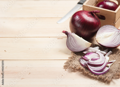 Red onion and cutting board on wooden table  selective focus