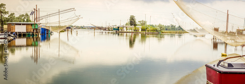 fishing huts in the quiet of brackish lagoon photo