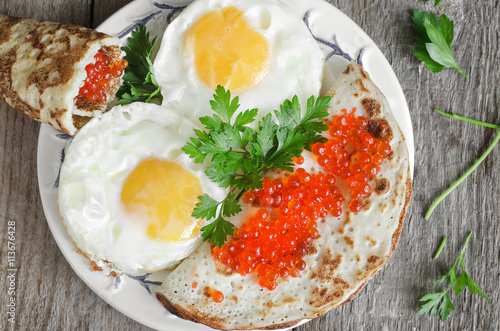Tableau sur toile Scrambled eggs and pancakes with red caviar