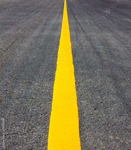  Asphalt surface of the road with a yellow line.
