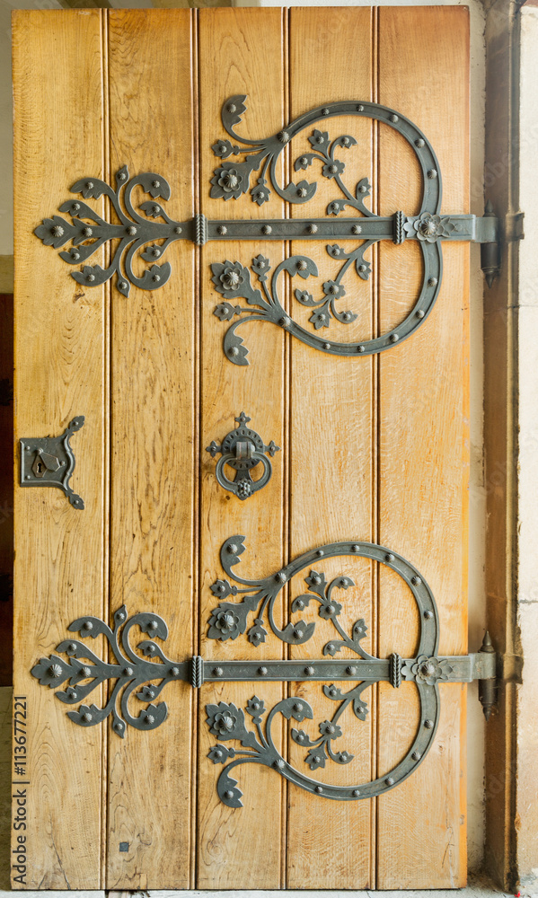 Detail of a wooden door with a handle, wrought iron handle. Detail of a wooden door with a handle, wrought iron handle.