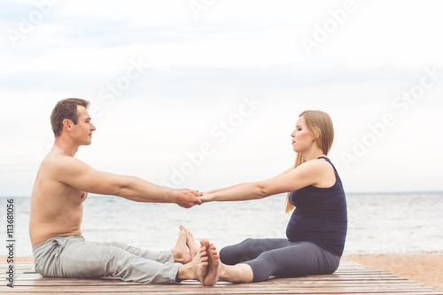 Couple are doing stretching at coast