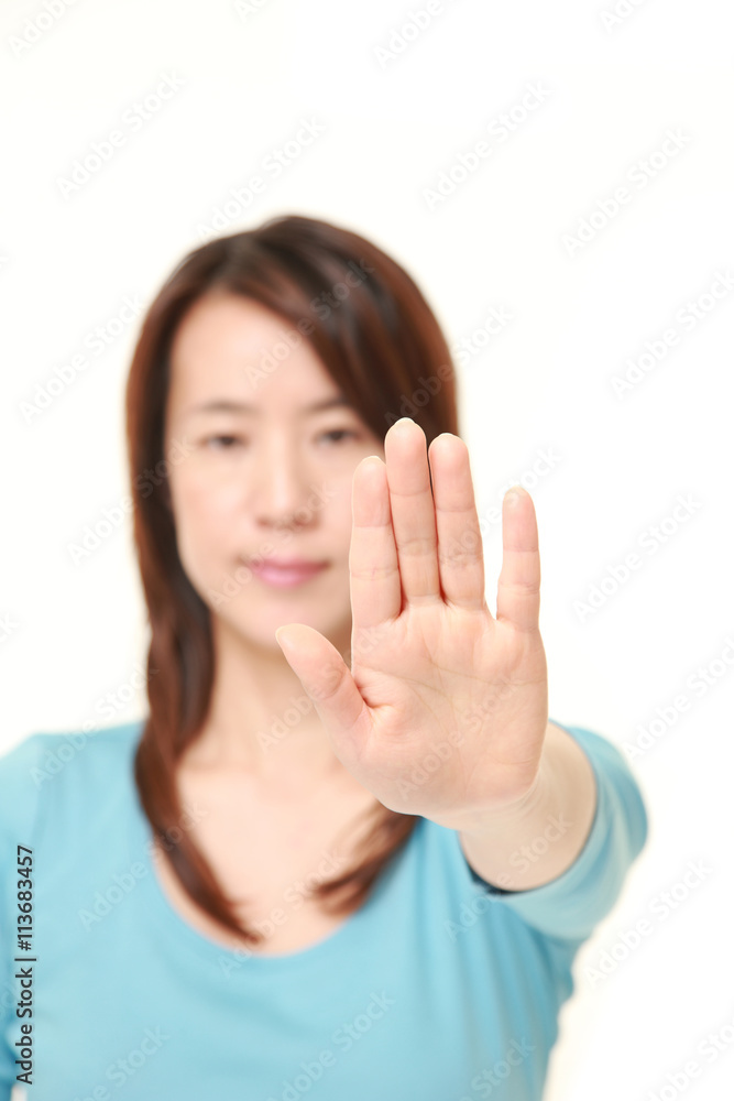 middle aged Japanese woman making stop gesture