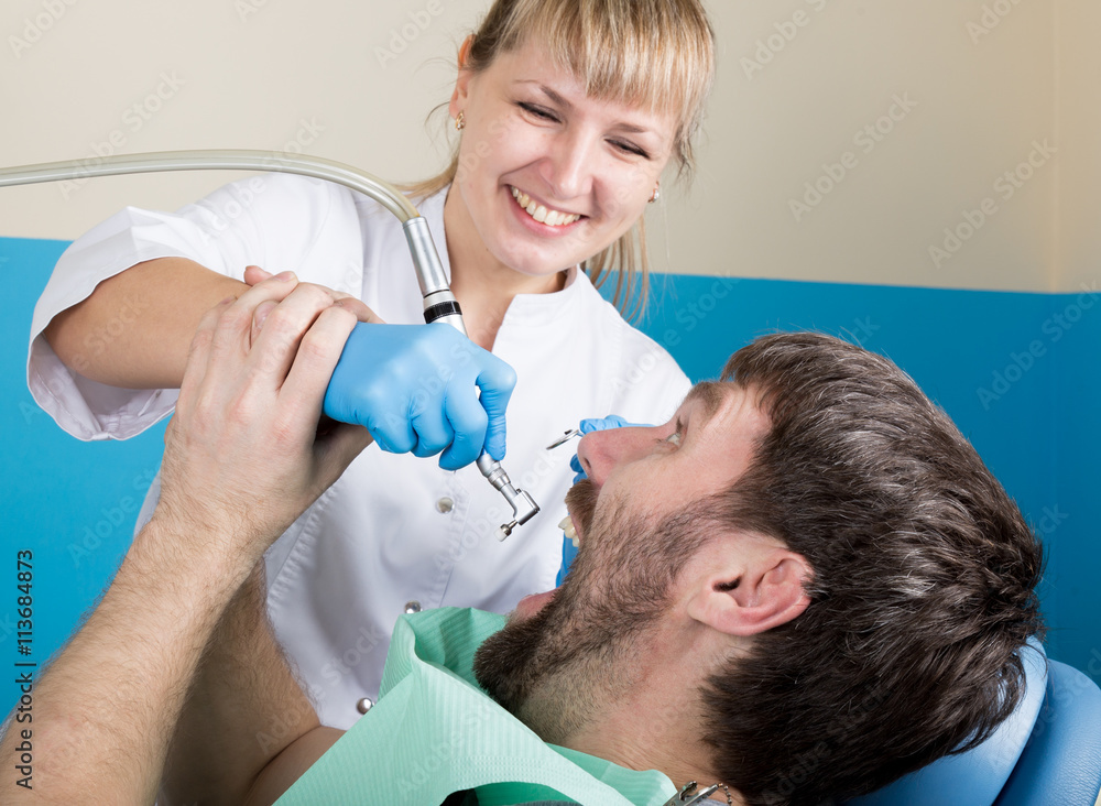 Doctor examines the oral cavity on tooth decay. Caries protection. Tooth decay treatment. Dentist working with dental polymerization lamp in oral cavity Doctor examines the oral cavity on tooth decay. Caries protection. Tooth decay treatment. Dentist working with dental polymerization lamp in oral cavity