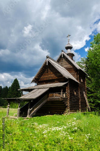 Ancient traditional Russian Orthodox wooden church on a meadow in the woods