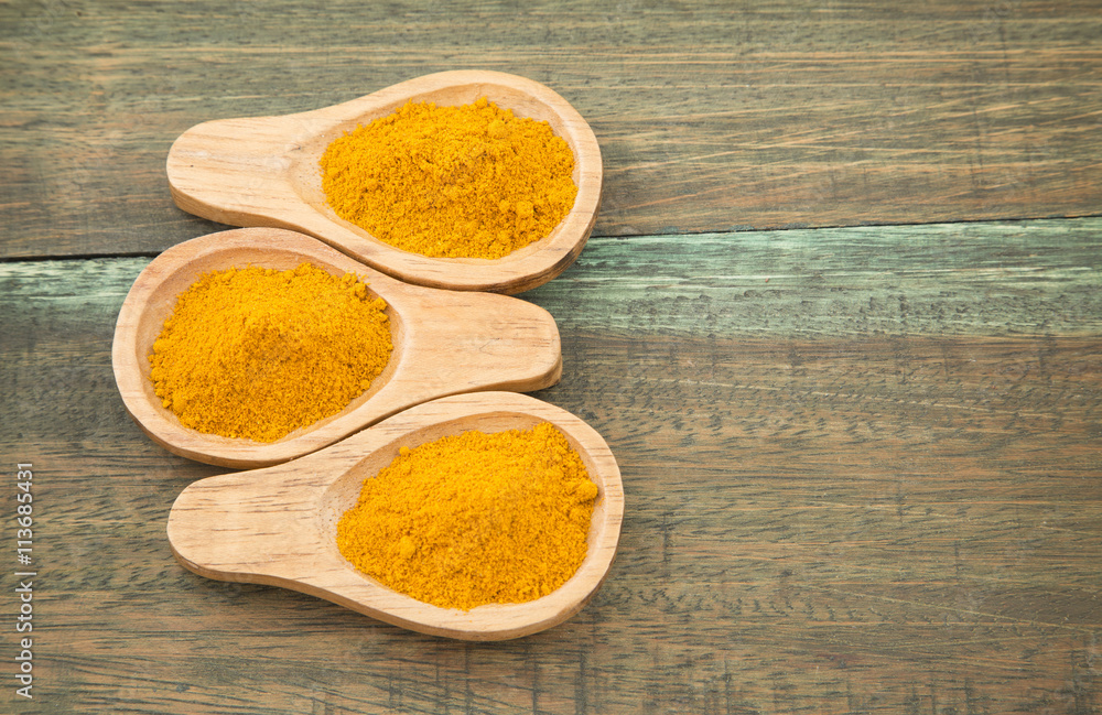 Turmeric powder on wooden background Turmeric powder on wooden background