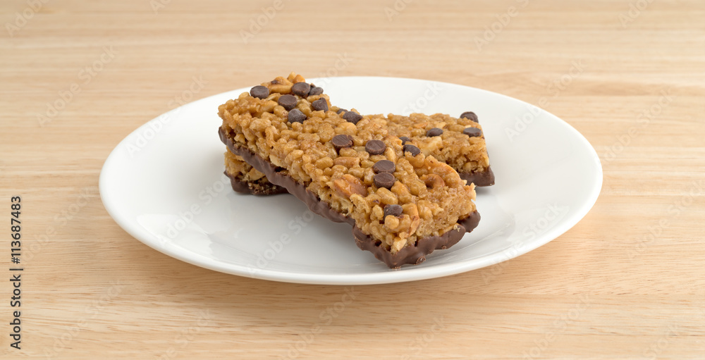 Chocolate chip peanut protein bars on a wood table top side view. Chocolate chip peanut protein bars on a wood table top side view.