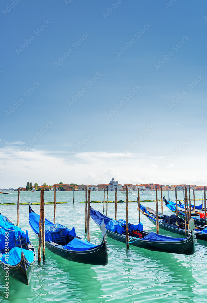 Several gondolas parked beside the Riva degli Schiavoni. Venice
