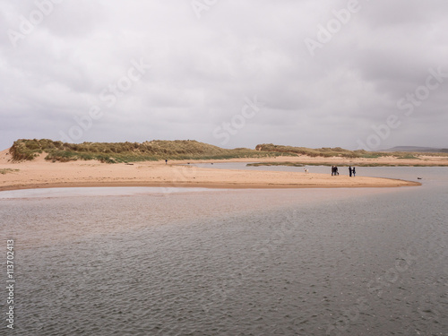 Visitors enjoying a walk along the beach at Lossiemouth, Morray Firth, Scotland, UK, photo