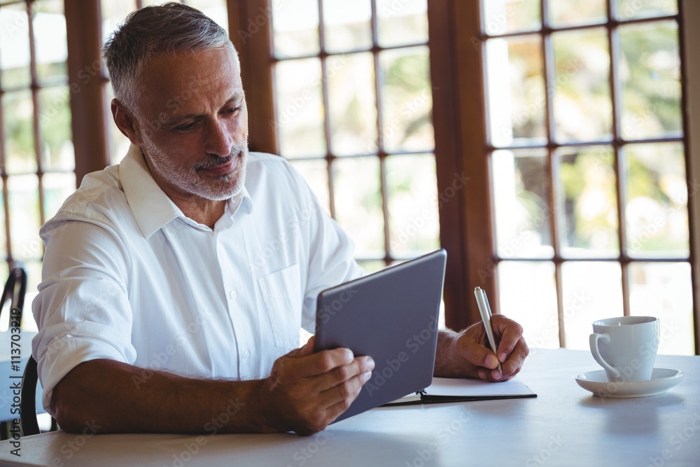 Man using tablet and notebook Man using tablet and notebook