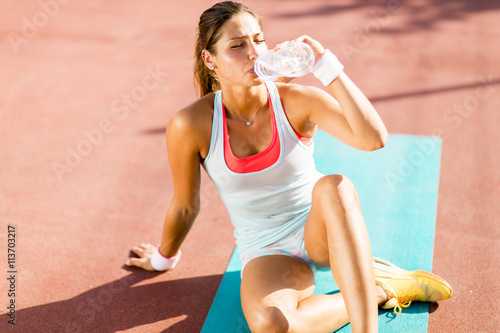 Sporty young woman drinking...
