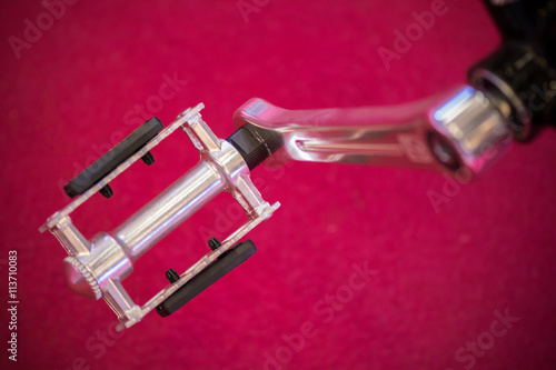 Closeup view of mountain bike pedal. Bicycle's pedal on a red ba