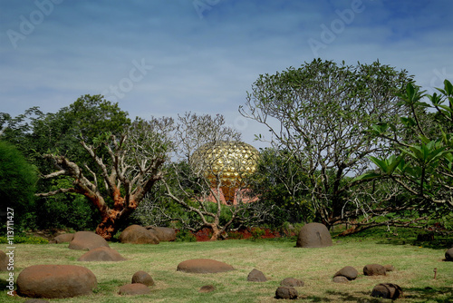 Golden dome of the temple Matrimandir peeps through the trees ad