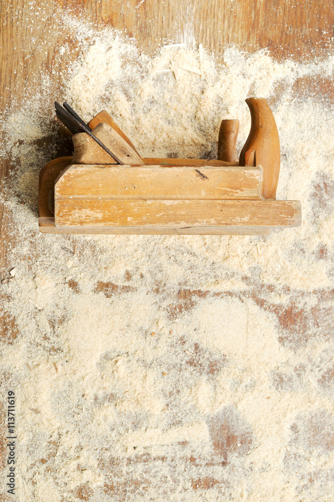 Carpenter tools on wooden table with sawdust.
