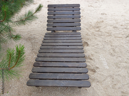 Wooden deck chair, pine and inscription of shells "Summer" on a clean sea sand on the beach. You can use to create articles about a beach holiday or create advertising 