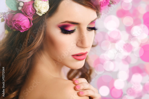 Beautiful young woman wearing floral headband on festive background