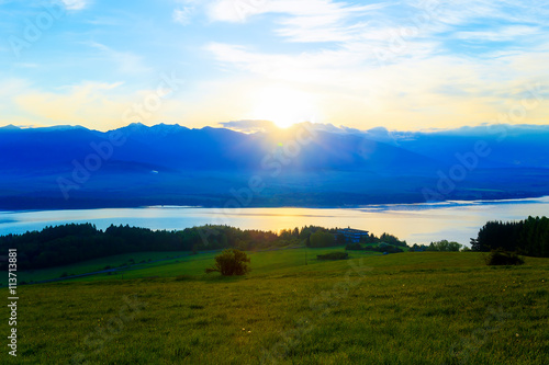 Beautiful landscape, green meadow and lake with mountain in background. Slovakia, Central Europe.
