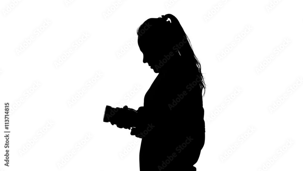 Photographer attaches to the lens and makes photography. White. Silhouette Photographer attaches to the lens and makes photography. White. Silhouette