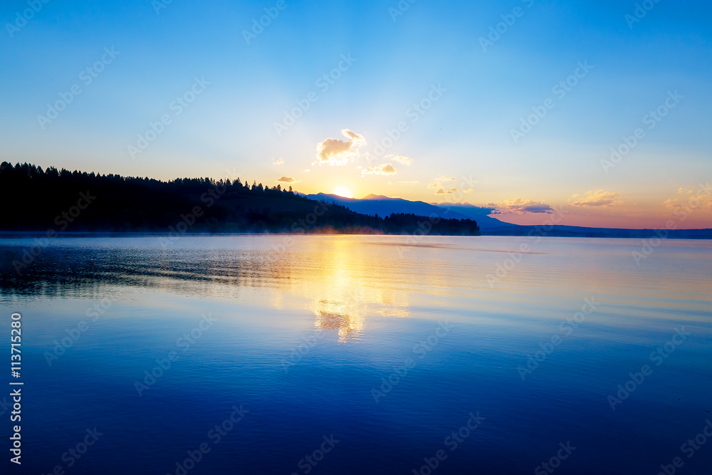 beautiful landscape with mountains and lake at dawn in golden, blue and purple tones. Slovakia Liptovska Mara, in region Liptov.