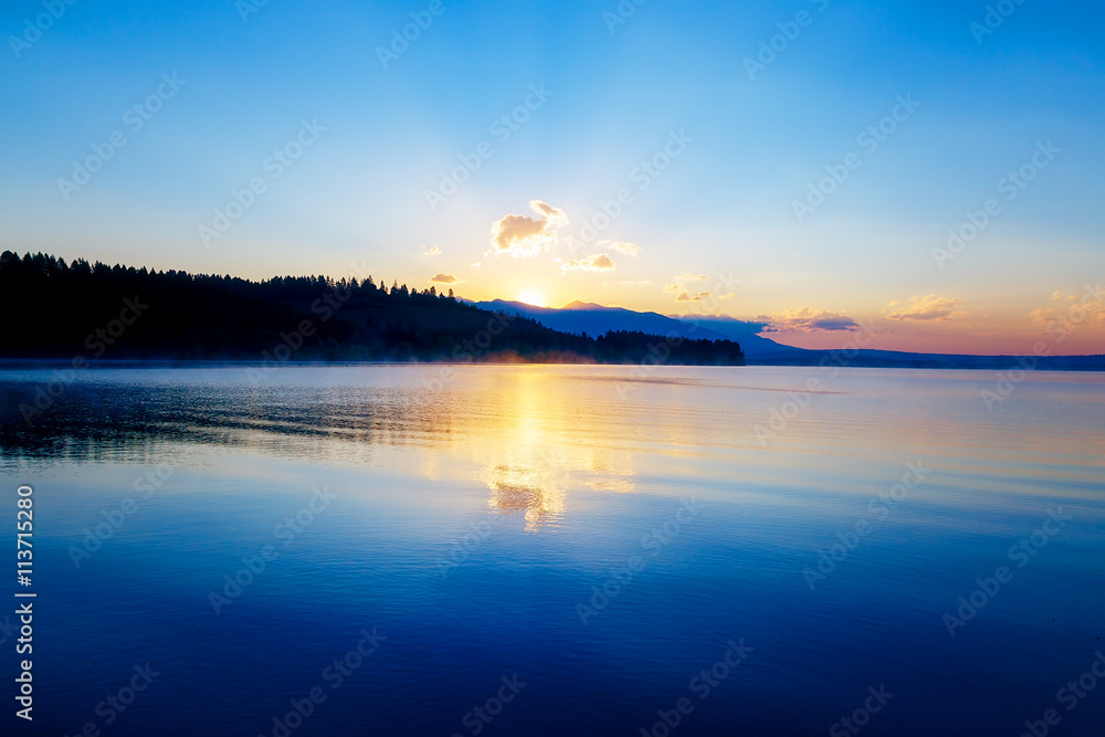 Fototapeta premium beautiful landscape with mountains and lake at dawn in golden, blue and purple tones. Slovakia Liptovska Mara, in region Liptov.