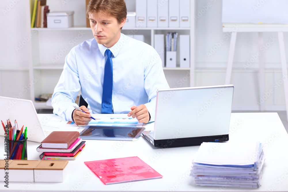 Young businessman working in office, sitting at a table Young businessman working in office, sitting at a table