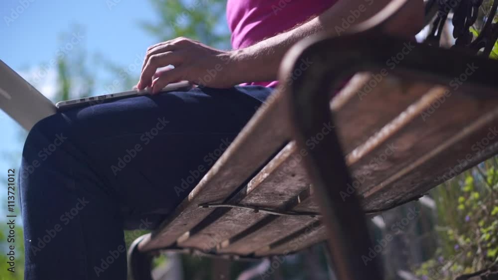 Man sitting on a bench with a laptop, and then will go outdoors Man sitting on a bench with a laptop, and then will go outdoors