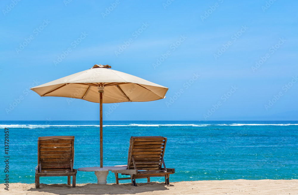 Sun lounger on tropical beach with a umbrella looking out to the horizon on a perfect sunny day in Bali