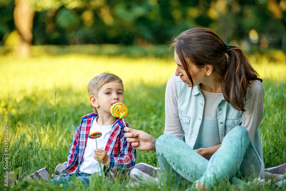 Mother with baby in the park eating sweets. Mother with baby in the park eating sweets.