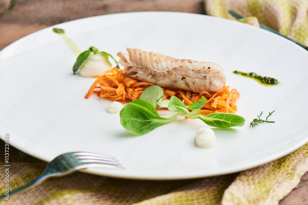 Dinner of Pollock in the marinade, served on a white plate Dinner of Pollock in the marinade, served on a white plate
