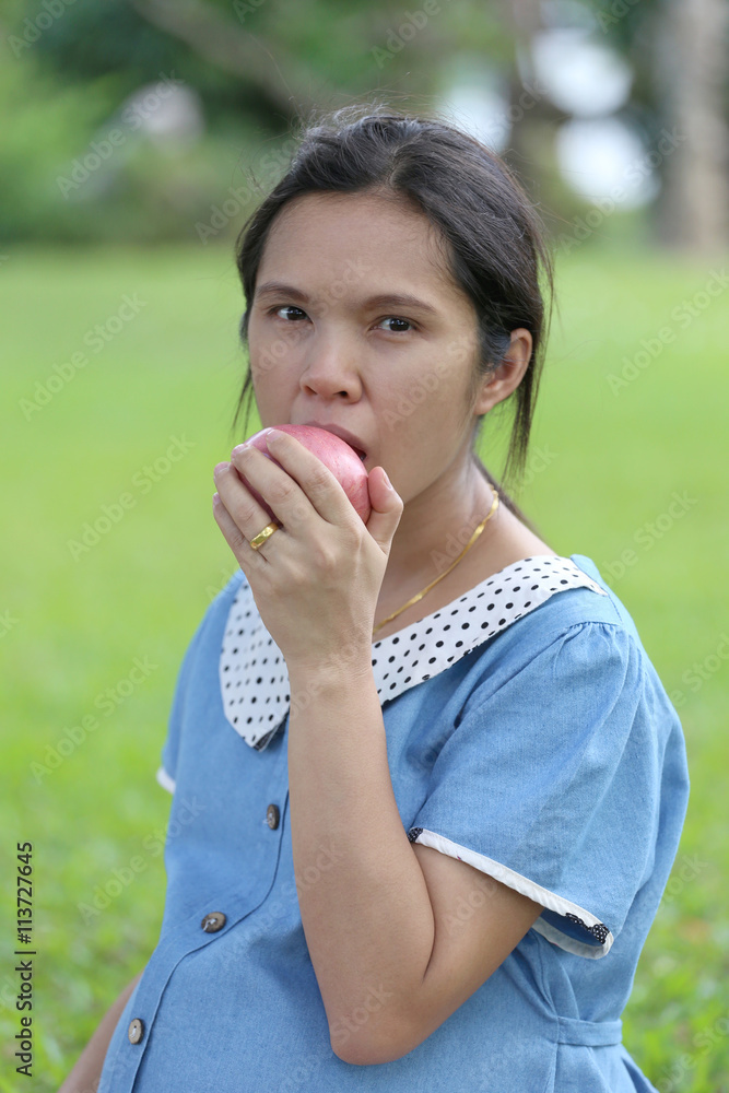 Asian pregnant women using hand catch apple up eating. Asian pregnant women using hand catch apple up eating.