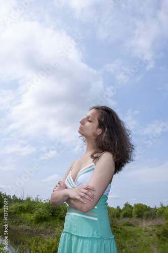 Girl with closed eyes on a background of blue sky