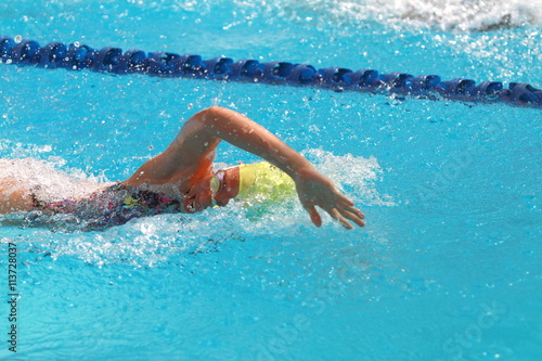 Woman with yellow swimming cap swim in the swimming pool
