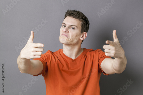 Canvas Print bullying young man targeting the foreground with indexes like guns