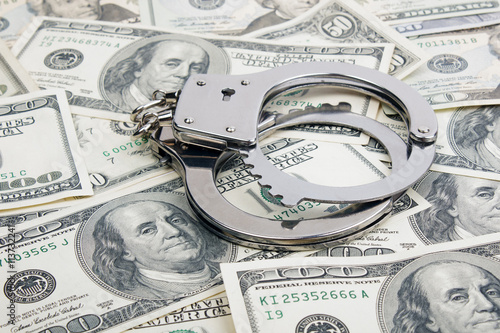 Lot of one hundred dollar bills and handcuffs.