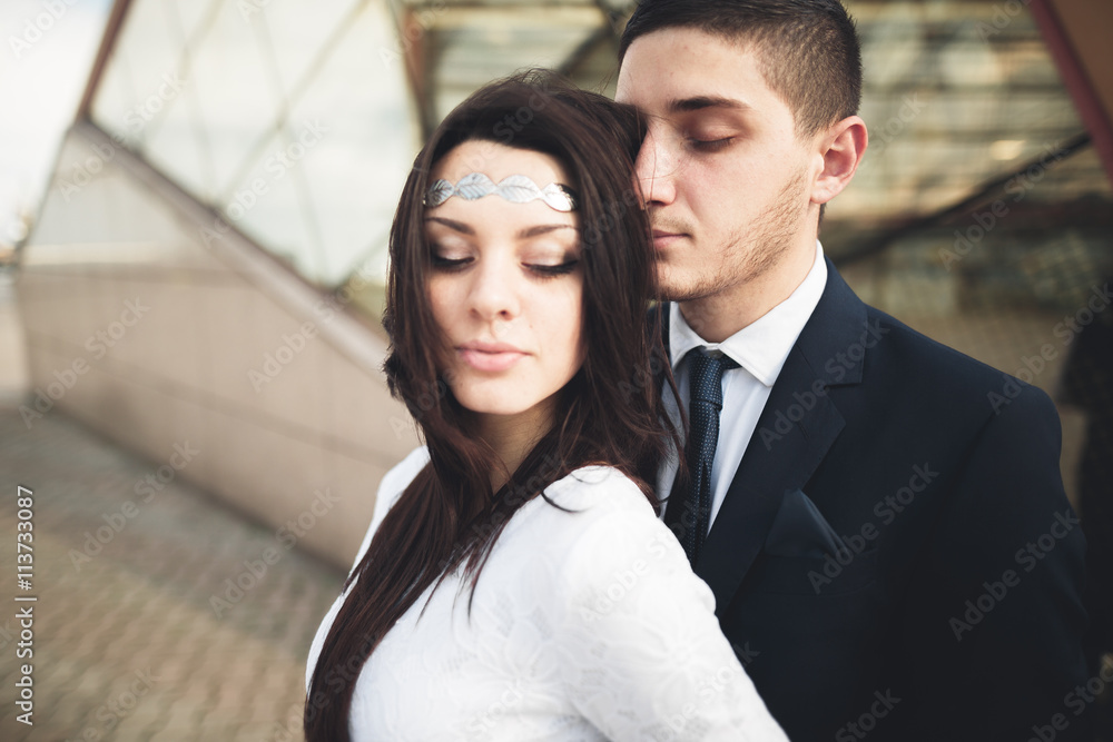 Elegant beautiful couple posing near modern glass building Elegant beautiful couple posing near modern glass building