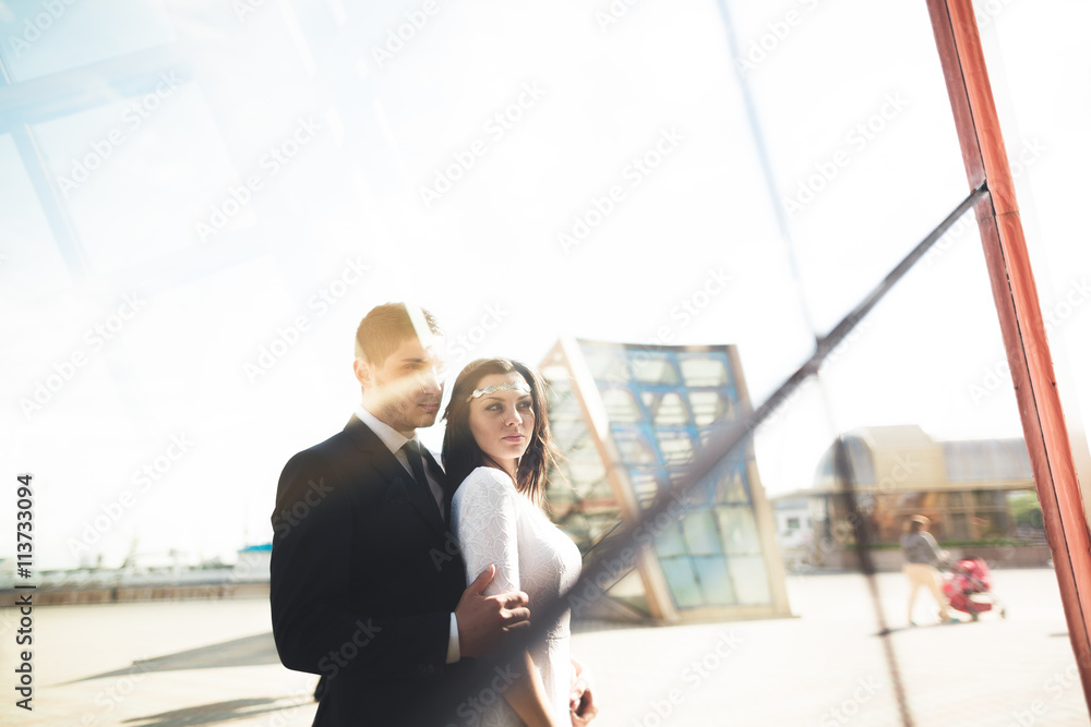 Elegant beautiful couple posing near modern glass building Elegant beautiful couple posing near modern glass building