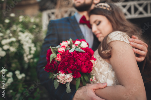 Kissing wedding couple in spring nature close-up portrait