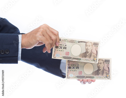 Hand holding Japanese banknote on white background. Japanese mon
