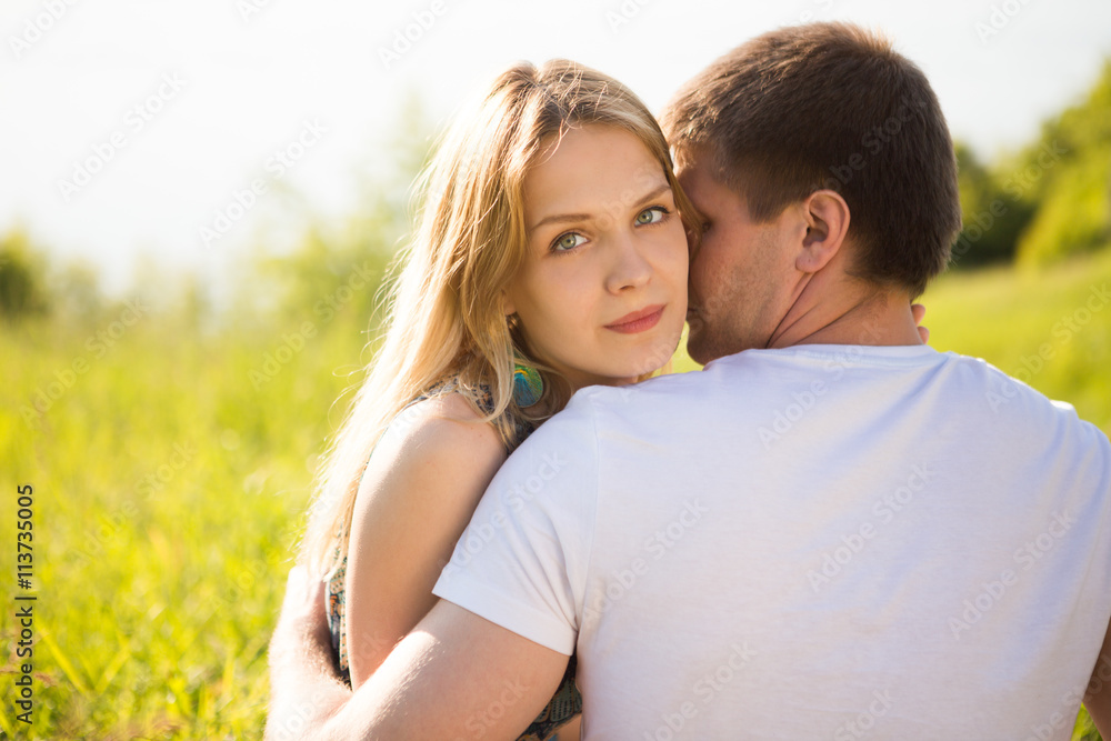Young couple in love outdoor. ?ortrait of young stylish fashion couple posing in summer in field Young couple in love outdoor. ?ortrait of young stylish fashion couple posing in summer in field