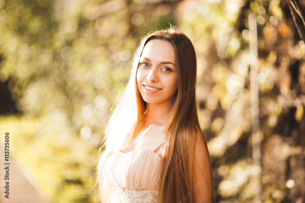 Attractive young woman with long dress enjoying her time outside in park sunset background Attractive young woman with long dress enjoying her time outside in park sunset background