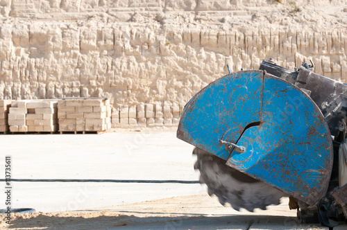 Circular sawing machine in action in a tufa quarry while carving the stone