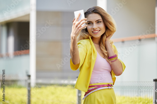 Beautiful blonde young woman wearing yellow dress walking 